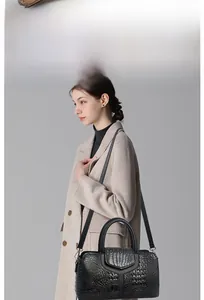 Detail view of crocodile-pattern leather bag with Y-shaped stitching and dual handles