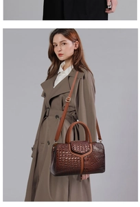 Detail of a brown crocodile pattern handbag worn over the shoulder by a model