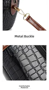 Close-up of golden metal clasp and crocodile texture on black faux leather bag