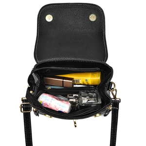 Black lychee leather crossbody bag shown open with multiple interior storage compartments