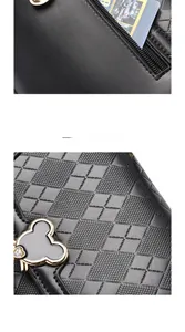 Detailed view of black quilted leather handbag with Mickey Mouse metal charm and zipper pocket