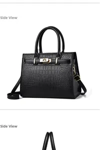 Détail du sac à main noir texture crocodile avec fermoir doré et bandoulière amovible