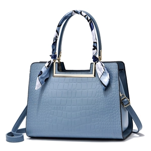 Elegant light blue crocodile embossed handbag with silk scarf handle and crossbody strap