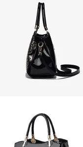 Detail view of glossy patent leather handbag with gold floral sequins and metal hardware
