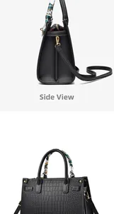 Detailed side view of black crocodile pattern handbag with elegant green silk scarf on handle