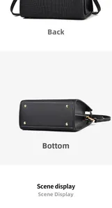 Detailed view of the black crocodile pattern handbag showing the base with gold metal feet