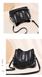 Detail of black leather bucket bag with 3D ripple texture and gold clasp buckle