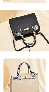 Detail of luxury crocodile embossed PU leather handbag with silk scarf on handle