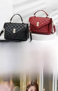 Detail of quilted leather handbag with V-stitch pattern and gold metal clasp