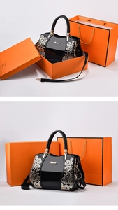 Detail of black patent leather Boston bag featuring floral sequins and gold hardware