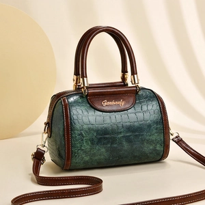 Deep green crocodile embossed Boston bag with brown trim and gold logo detail