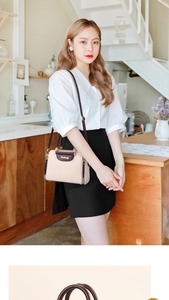 Detail of beige and brown contrast handbag with gold side zippers and logo lettering