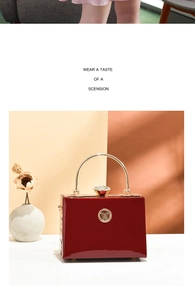 Detail of red patent leather mini clutch bag with golden handle and crystal clasp
