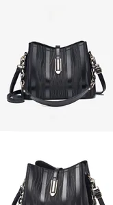Front macro view of black bucket bag featuring textured fabric and polished gold hardware