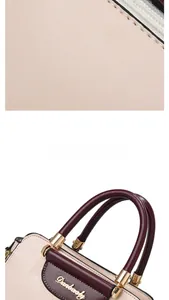 Detail of lychee pattern leather handbag with burgundy handles and gold hardware
