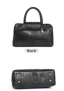 Detail view of black crocodile pattern bag showing back zipper pocket and bottom gold studs