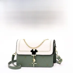 Close-up of heart-quilted green leather bag with Mickey-shaped lock and star pendant