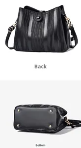 Detailed back and bottom views of a black bucket bag with golden feet and textured leather