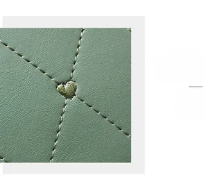 Close-up of bean green leather shoulder bag with quilted diamond pattern and heart embroidery