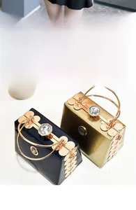 Close-up of mini glossy evening bags with large jewel clasp and metal petal accents