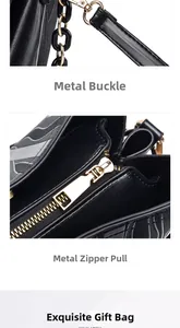 Detail of gold metal hardware clasps and smooth zipper on textured black leather bag