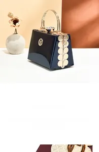 Detail of blue patent leather bag with gold metal handle and crystal clasp closure