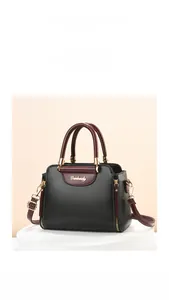Detail of contrast stitching and gold metal hardware on the black and red handbag
