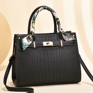 Classic black crocodile pattern handbag with gold hardware and decorative silk scarf