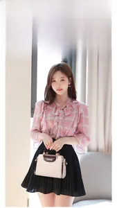 Fashionable beige contrast handbag styled with a pink plaid chiffon top and black pleated skirt