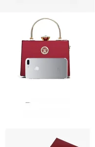 Detailed interior capacity of the red patent leather mini bag with phone and accessories