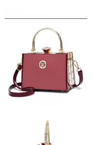 Deep red patent leather mini handbag with gold metal handle and jewel-encrusted clasp detail