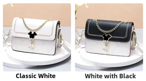 Detail view of heart-quilted flap bag with mouse-shaped metal clasp and golden chain