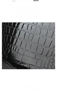Detail view of premium black crocodile embossed leather material with a glossy finish