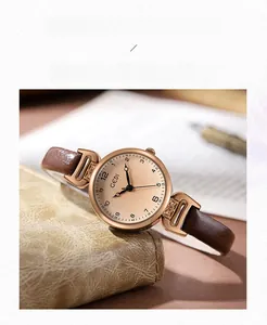 Elegante orologio da donna in oro rosa con cinturino in pelle marrone su scrivania