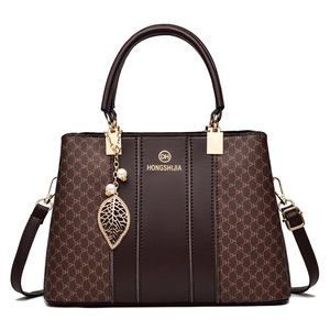 Elegant brown leather handbag with DH monogram pattern and gold leaf charm detail