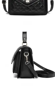 Detail view of black quilted leather bag with golden twist lock and sturdy handle