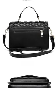 Detail of black quilted crossbody bag showing back zipper pocket and golden hardware