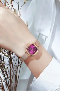 Close-up of square purple dial watch with rose gold mesh strap on a female wrist
