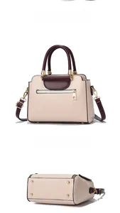 Detail of two-tone handbag with metal base feet and wine red detachable shoulder strap