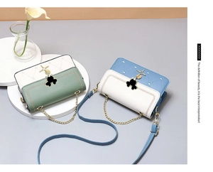 Detail of crossbody bags with heart quilting, dual straps, and gold chain handles