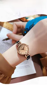 Primo piano di un elegante orologio in oro rosa con cinturino in pelle nera indossato