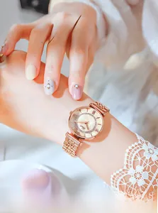 Detail of rose gold quartz watch with rhinestone bezel and metal five-link bracelet