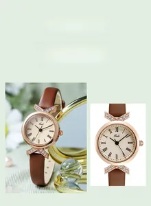 Detail of elegant ladies quartz watch with thin brown leather strap and rose gold rhinestone case