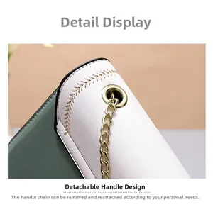 Detail of green and white leather bag with detachable gold metal chain and brown stitching
