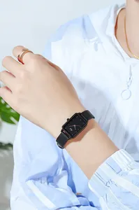 Primo piano di un orologio al quarzo quadrato con quadrante nero e cinturino in pelle