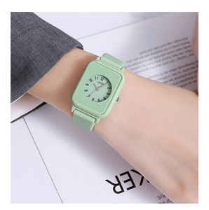 Close-up of mint green square quartz watch with silicone strap on woman's wrist