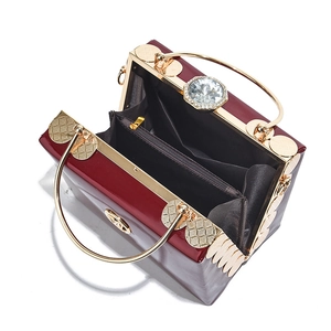 Deep red patent leather mini box bag with gold handles and crystal clasp detail