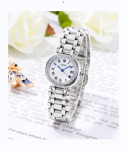 Détail d'une montre argentée pour femme avec lunette en cristal et aiguilles bleues