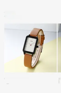 Dettaglio di un orologio quadrato da donna con cinturino in pelle marrone e cassa nera