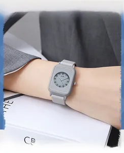 Close-up of minimalist square grey silicone watch on wrist with clear numeric markers